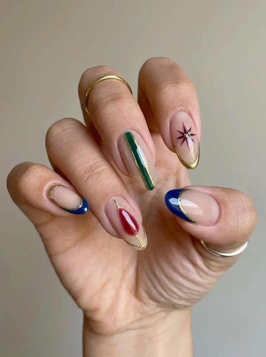 Jewel-Tone Christmas Nails With Gold Outlines - Nude base with sapphire blue, emerald green, and ruby red art framed in gold