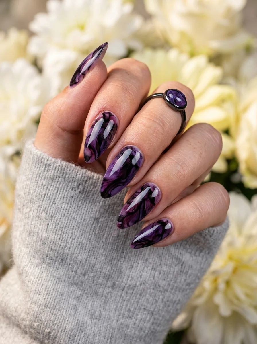 Long almond nails with a swirling marble pattern in deep purple, violet, and black tones.