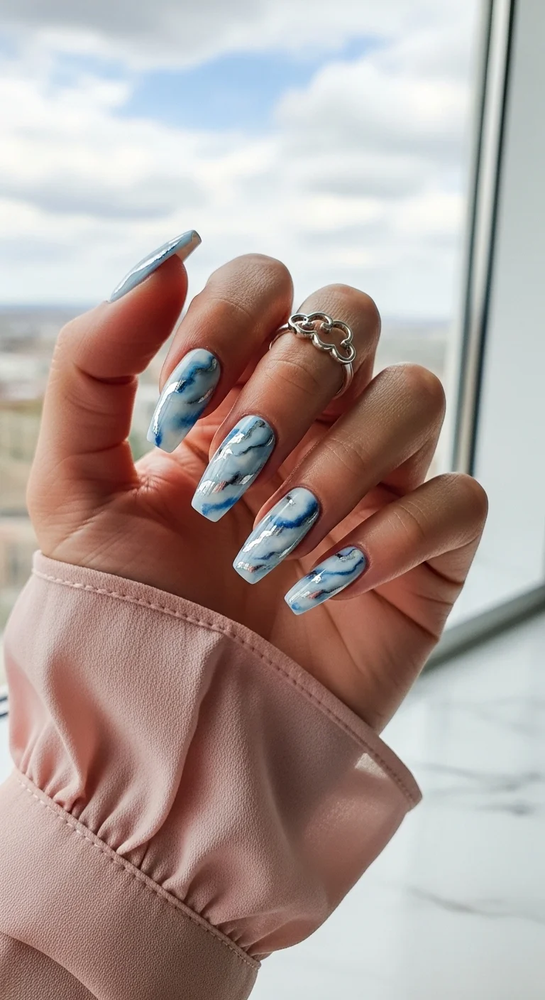 Blue and white marble nails with silver foil veins.